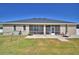 Home's rear exterior shows a screened-in lanai, patio, and a spacious green backyard at 2110 Saddlewood Dr, Bartow, FL 33830