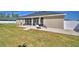 View of the home's rear exterior featuring a screened-in lanai, patio, and a spacious backyard at 2110 Saddlewood Dr, Bartow, FL 33830