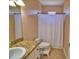 Well-lit bathroom featuring a granite countertop and a shower with a white curtain at 2110 Saddlewood Dr, Bartow, FL 33830
