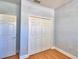 Bright bedroom with wood floor, and a spacious closet with white doors, offering comfort and style at 2110 Saddlewood Dr, Bartow, FL 33830