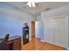 Cozy bedroom with a ceiling fan, closet, wood floor and blue walls, offering comfort and style at 2110 Saddlewood Dr, Bartow, FL 33830