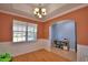 This elegant dining room has an arched entry, wainscoting, and a chandelier at 2110 Saddlewood Dr, Bartow, FL 33830