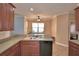 Open concept kitchen with a black dishwasher, stainless steel faucet and wood cabinets at 2110 Saddlewood Dr, Bartow, FL 33830