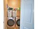 This laundry room has a washer and dryer with a shelf for organizing laundry supplies at 2110 Saddlewood Dr, Bartow, FL 33830