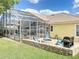 Backyard features a brick patio with a fire pit, seating, and a view of the screened pool at 2204 Kettle Dr, Orlando, FL 32835