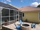 Backyard features a brick patio with a fire pit, seating, and a view of the screened pool at 2204 Kettle Dr, Orlando, FL 32835