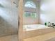Tiled shower stall and luxurious soaking tub with a window at 2204 Kettle Dr, Orlando, FL 32835