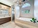 A luxurious bathroom featuring a modern vanity, soaking tub, and a glass-enclosed shower at 2204 Kettle Dr, Orlando, FL 32835
