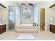 Luxurious bathroom featuring a soaking tub, separate shower, dual vanities, and a stylish chandelier at 2204 Kettle Dr, Orlando, FL 32835