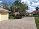 Exterior view showing a brick paved driveway leading to a well-maintained home with lush landscaping at 2204 Kettle Dr, Orlando, FL 32835