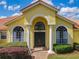 Close-up of home's grand arched entry with double doors, white columns, and manicured bushes at 2204 Kettle Dr, Orlando, FL 32835