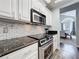 Kitchen area featuring modern oven, stove, microwave and stylish backsplash with granite countertops at 2204 Kettle Dr, Orlando, FL 32835