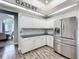 Galley kitchen showcasing modern stainless steel refrigerator, white cabinetry, and decorative backsplash at 2204 Kettle Dr, Orlando, FL 32835