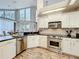 Modern kitchen featuring granite countertops, stainless steel appliances, white cabinetry, and hardwood floors at 2204 Kettle Dr, Orlando, FL 32835