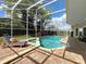 A beautiful screened-in pool with jacuzzi and stylish brick deck with a chair at 2204 Kettle Dr, Orlando, FL 32835