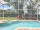 A beautiful screened-in pool surrounded by lush landscaping and a stylish brick deck at 2204 Kettle Dr, Orlando, FL 32835