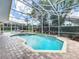 Screened in pool area with brick pavers, tropical landscaping, and lounge chairs at 2204 Kettle Dr, Orlando, FL 32835