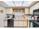 The kitchen features a large skylight and white cabinets with black appliances at 2254 Firestone Pl # 2254, Winter Haven, FL 33884