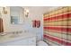 Well-lit bathroom featuring a white vanity, a matching toilet and a striped shower curtain at 2300 N Scenic Hwy # 89, Lake Wales, FL 33898