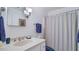 Bright bathroom with a white vanity, classic fixtures, and a blue-striped shower curtain at 2300 N Scenic Hwy # 89, Lake Wales, FL 33898