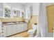 Classic bathroom featuring double sinks, yellow tile, shower with curtain, and abundant natural light at 2300 N Scenic Hwy # 61, Lake Wales, FL 33898