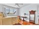 Bright bedroom features hardwood floors, large window, ceiling fan, table, and ornate wooden mirror at 2300 N Scenic Hwy # 61, Lake Wales, FL 33898