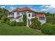 Two-story house with red tiled roof and manicured lawn with lush green shrubbery at 2300 N Scenic Hwy # 61, Lake Wales, FL 33898
