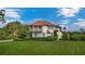 Beautiful white house with manicured lawn, red tile roof, and lush green shrubbery at 2300 N Scenic Hwy # 61, Lake Wales, FL 33898