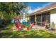 Spacious backyard featuring a screened lanai, brick patio with colorful seating, and lush landscaping at 315 Bayberry Dr, Polk City, FL 33868
