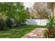 Green backyard with brick paver path and white privacy fence at 315 Bayberry Dr, Polk City, FL 33868