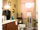 Functional bathroom with a vanity, toilet, mirror, and shelving unit at 318 Gladesdale St, Haines City, FL 33844