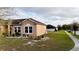 A quaint, single-story home boasts a well-manicured lawn and a side view of the home's exterior at 318 Gladesdale St, Haines City, FL 33844