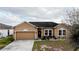 Charming single-story home featuring a well-maintained lawn and a two-car garage at 318 Gladesdale St, Haines City, FL 33844