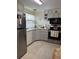 Bright kitchen features stainless steel appliances, neutral cabinetry, and modern tile flooring at 32 Berna Cir, Winter Haven, FL 33884