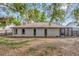 View of the back exterior of the home with a large yard and mature trees at 3323 Fox Ridge Dr, Winter Haven, FL 33884