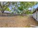 The large backyard boasts mature trees and a wooden fence, offering ample space for outdoor activities at 3323 Fox Ridge Dr, Winter Haven, FL 33884