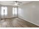 Bedroom featuring wood-look floors, ceiling fan, and bright windows with sheer curtains at 3323 Fox Ridge Dr, Winter Haven, FL 33884