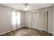 Bedroom featuring wood-look floors, ceiling fan, bright window, and closet with white doors at 3323 Fox Ridge Dr, Winter Haven, FL 33884