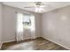 Bedroom featuring wood-look floors, ceiling fan, and bright window with sheer curtains at 3323 Fox Ridge Dr, Winter Haven, FL 33884