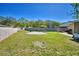 Spacious backyard with a mix of grass and sand, featuring a wooden fence and partial block wall for privacy at 3430 Cove E Ct, Winter Haven, FL 33880