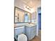 Bathroom with gray vanity, white commode and decorative mirror at 3430 Cove E Ct, Winter Haven, FL 33880