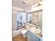 Bright bathroom featuring a vanity with solid surface top and tub with tile surround at 3430 Cove E Ct, Winter Haven, FL 33880