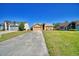 A charming single-story home with a two-car garage sits on a well-manicured lawn beneath a clear blue sky at 3430 Cove E Ct, Winter Haven, FL 33880