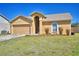 Inviting single-story home with a two-car garage, arched entryway, and a well-kept lawn with some shrubs at 3430 Cove E Ct, Winter Haven, FL 33880