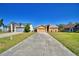 A charming single-story home with a two-car garage sits on a well-manicured lawn and long driveway at 3430 Cove E Ct, Winter Haven, FL 33880