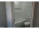Bright bathroom with white tiled tub and shower combo and commode at 3438 Avenue E Nw, Winter Haven, FL 33880
