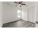 Bright bedroom with wood-look flooring, ceiling fan, window and double-door closet at 3438 Avenue E Nw, Winter Haven, FL 33880