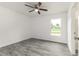 Light filled bedroom with wood-look floors, ceiling fan, window and white walls at 3438 Avenue E Nw, Winter Haven, FL 33880