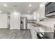 Well-lit kitchen featuring stainless steel appliances, granite countertops, and modern white cabinetry at 3438 Avenue E Nw, Winter Haven, FL 33880