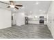 Open kitchen with stainless appliances, granite countertops, white cabinets, and modern gray flooring at 3438 Avenue E Nw, Winter Haven, FL 33880
